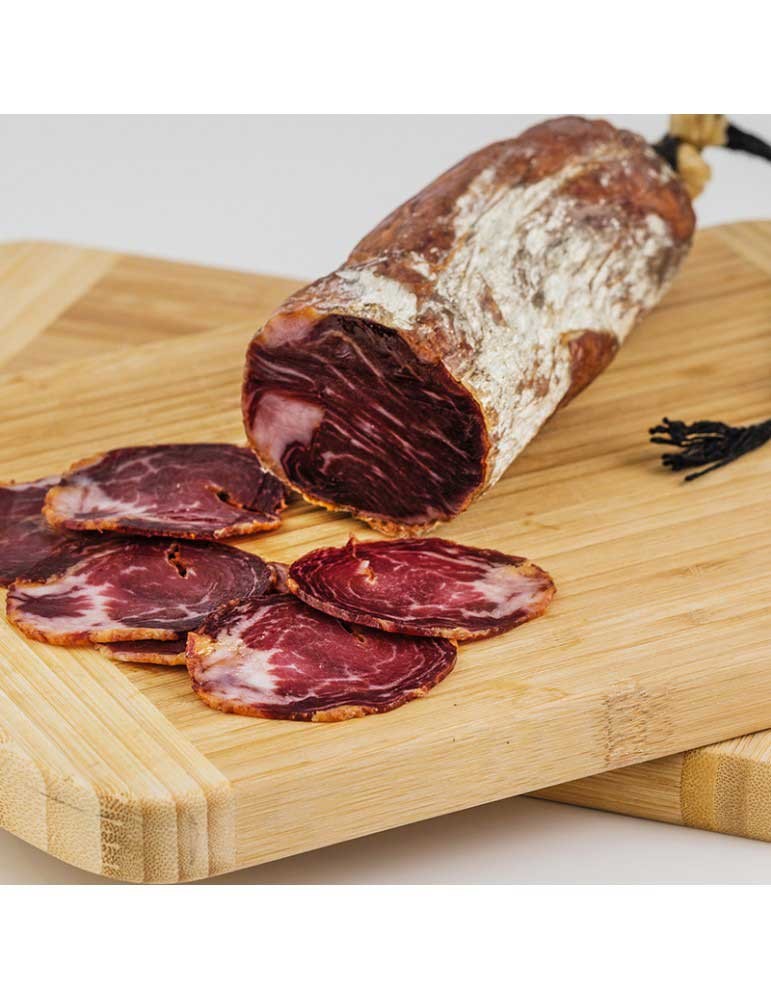 Lonchas de lomito ibérico de bellota de Los Romeros de Alanís sobre tabla; la pieza entera es solo de referencia